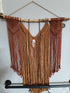 large red and orange macramé wall hanging with agate on a stick